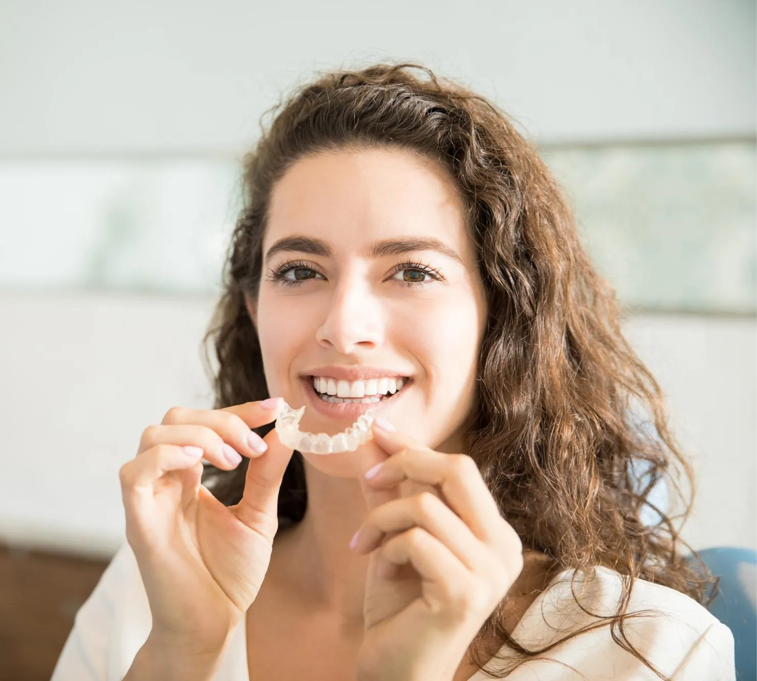 Patient placing a clear Invisalign aligner at Rancho Bernardo Dental Arts in San Diego